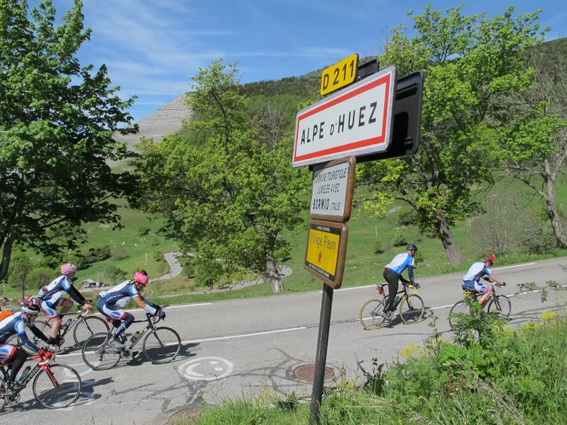 Schild Alpe D'Huez mit Radfahrern