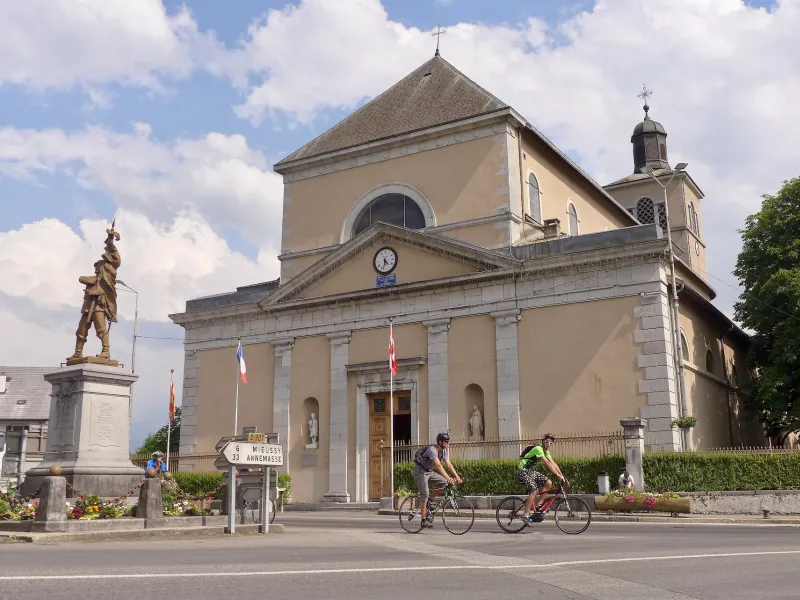 Radfahrer vor der Kirche Saint-Jean-Baptiste in Taninges