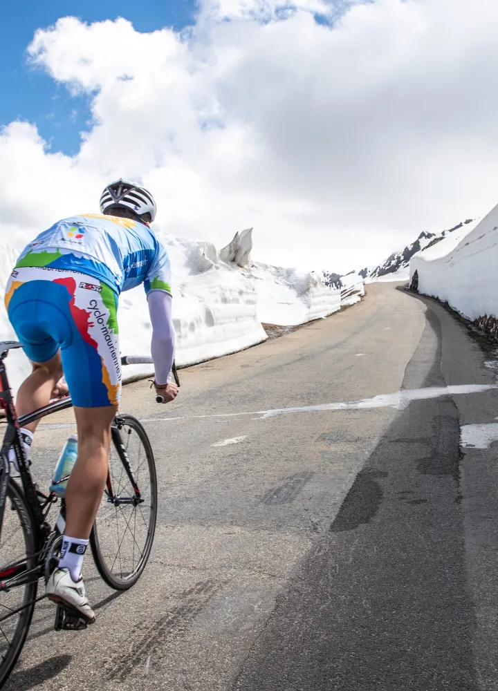 Radfahrer im Schnee auf der Route des Grandes Alpes