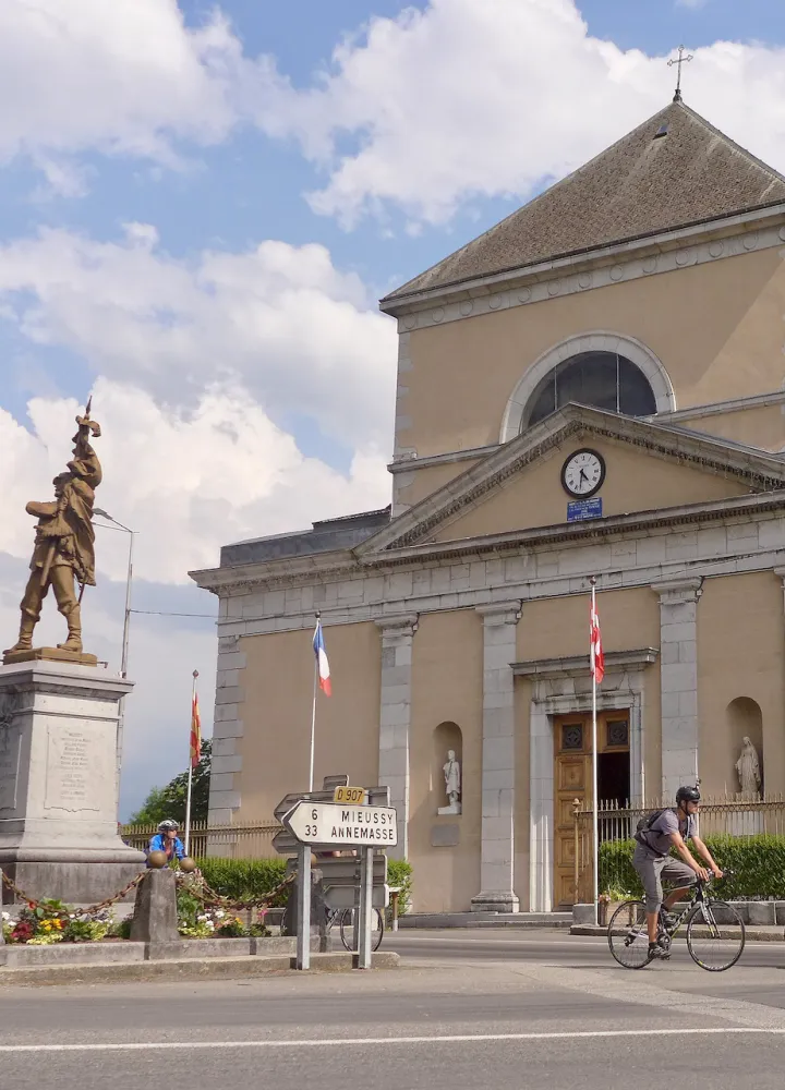 Radfahrer vor der Kirche Saint-Jean-Baptiste in Taninges