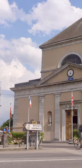 Radfahrer vor der Kirche Saint-Jean-Baptiste in Taninges