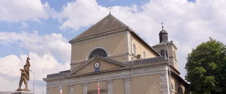 Radfahrer vor der Kirche Saint-Jean-Baptiste in Taninges