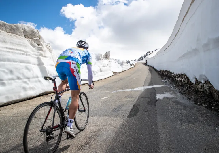 Radfahrer im Schnee auf der Route des Grandes Alpes